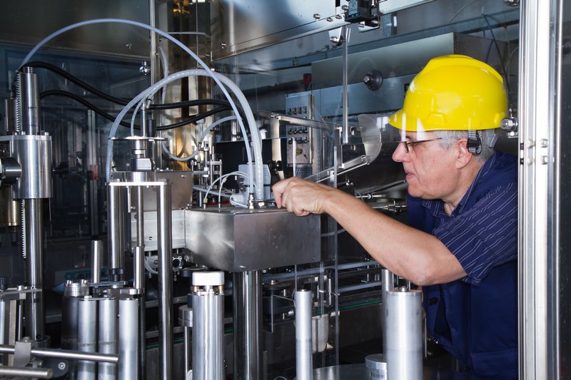 skilled worker while fixing a bottling plant during maintenance work